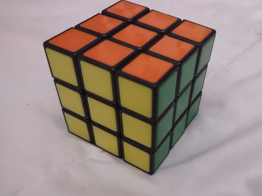 A rubiks brand rubiks cube. The image has been compressed vertically by a lot.